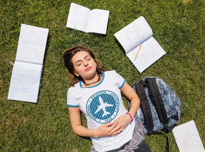 A student peacefully sleeping with books and a laptop nearby, symbolizing the connection between rest and academic success.