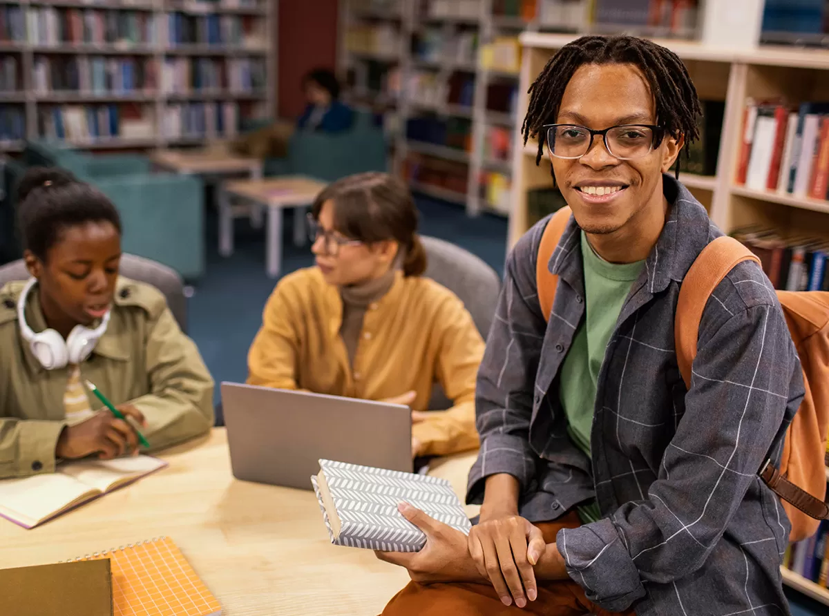 Study in Cameroon – Best Universities & Scholarship Programs A happy student at the library, focused on academic success.