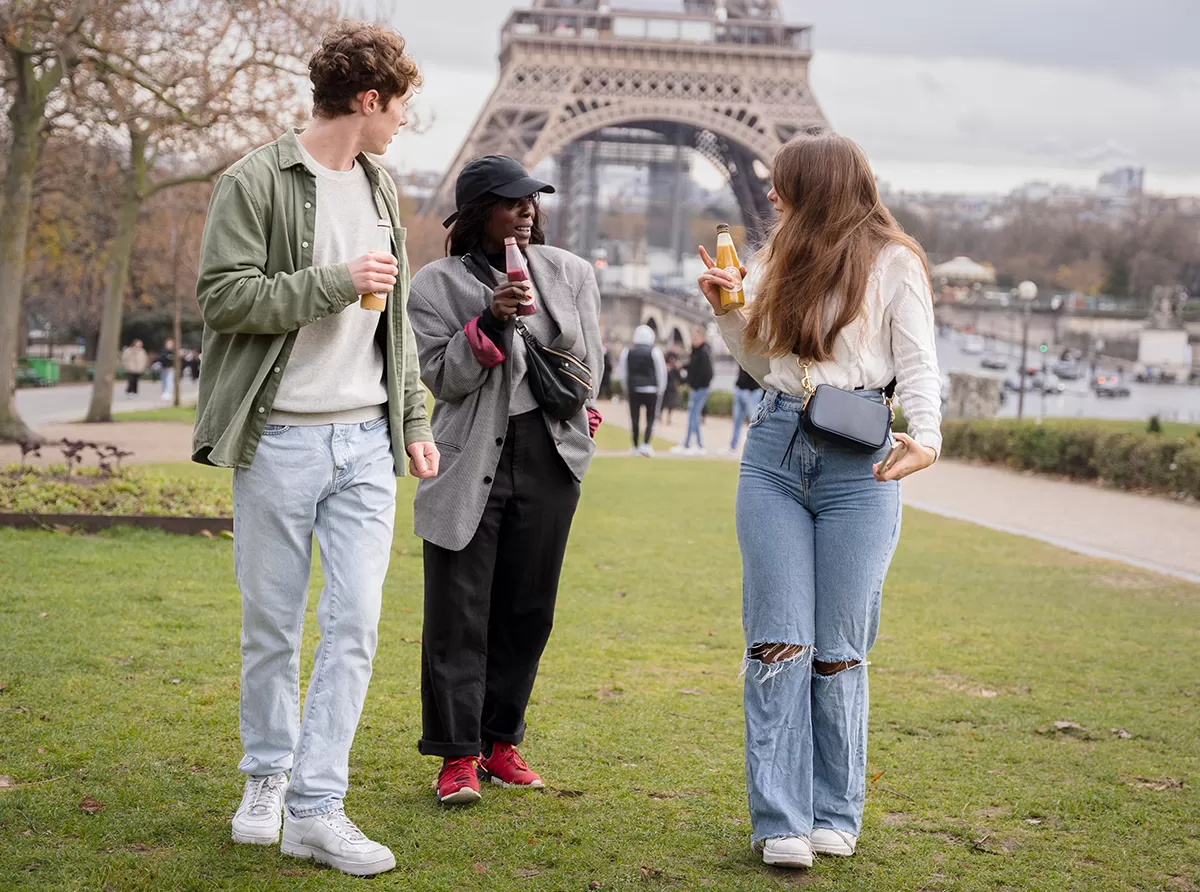 Study in France – Universities, Tuition & Study Costs Three students walking in front of the Eiffel Tower, enjoying their academic journey.