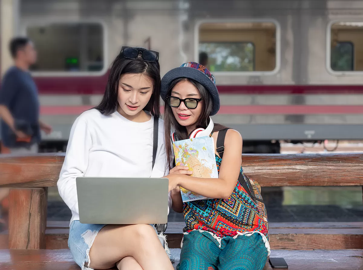 Study in Hong Kong – Best Universities & Global Education Two student girls studying at a metro station, balancing academics and city life.
