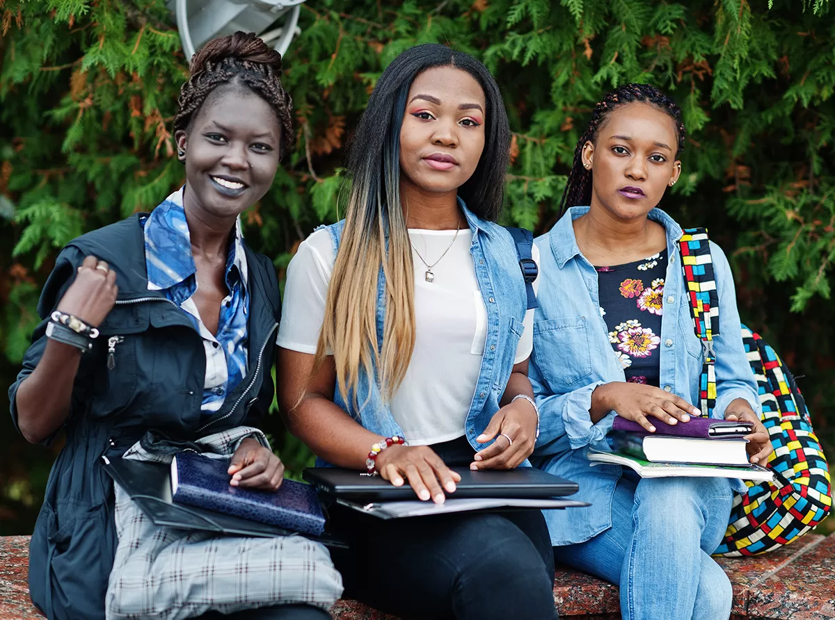 Study in Ivory Coast – Higher Education & Student Opportunities Three students sitting with books and studying together in a collaborative environment.